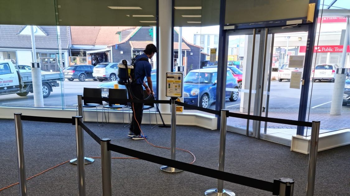 Our cleaner vacuuming the carpet in a commercial foyer