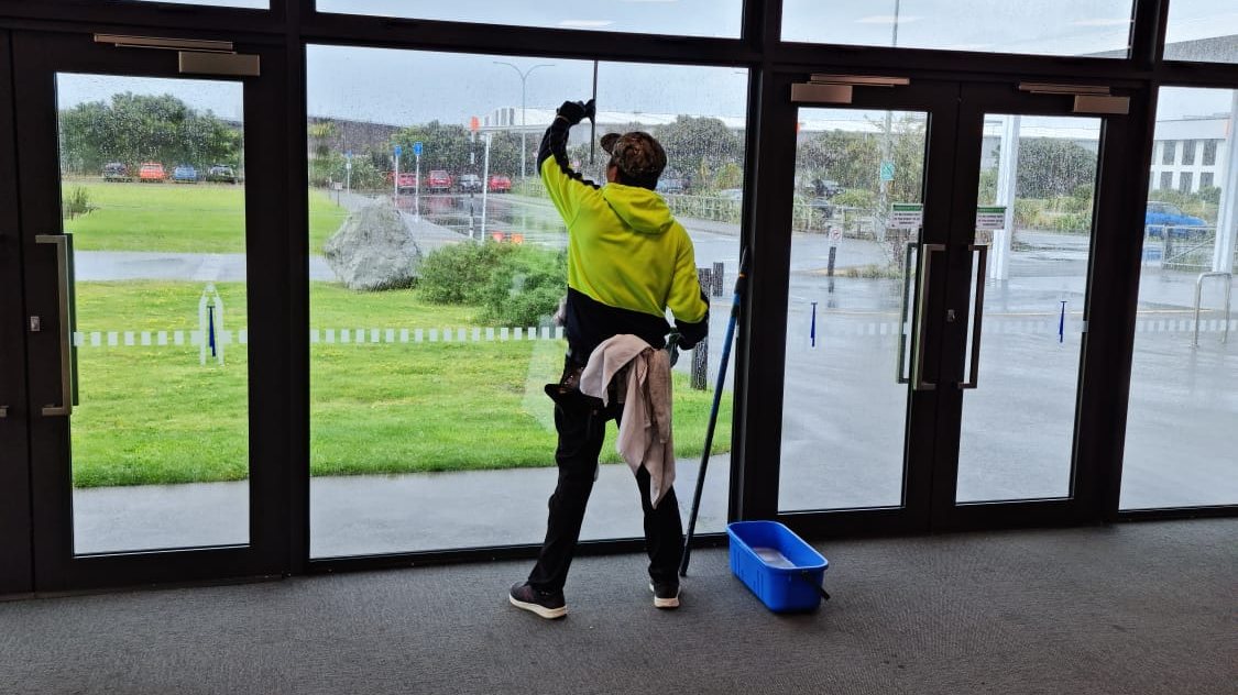 Our cleaner cleaning interior glass doors in a commercial building