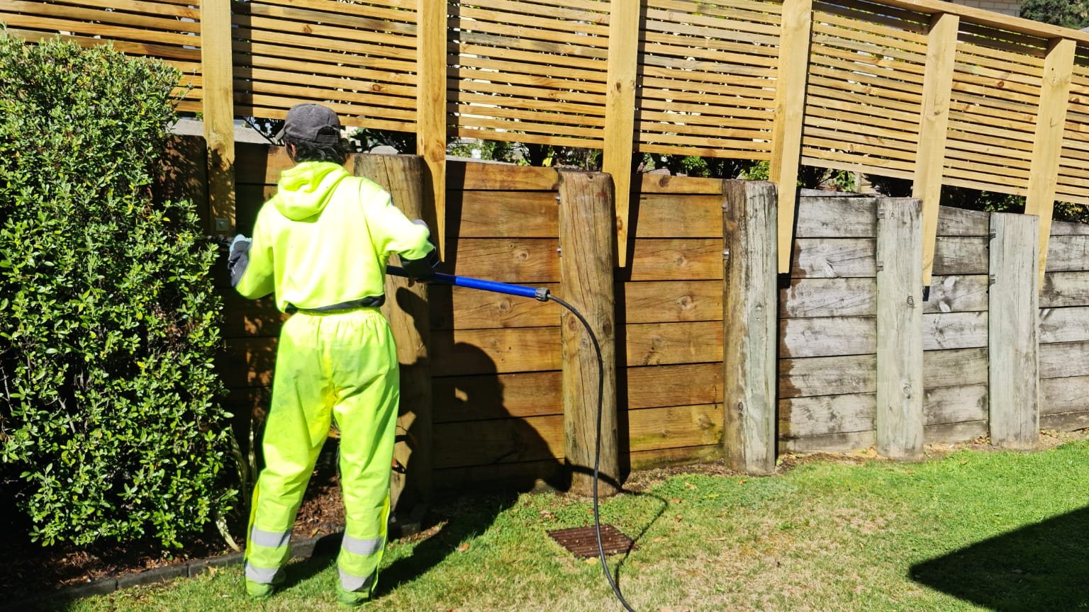 Our cleaner washing a timber fence with a pressure washer